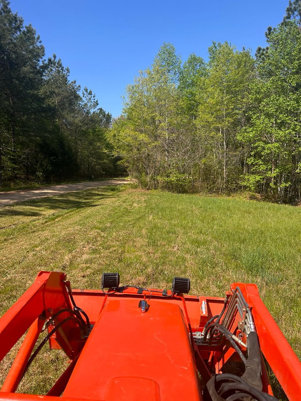 Olin on the tractor brush hogging the property
